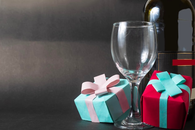 Valentines day concept Wine bottle and two gift boxes on black background