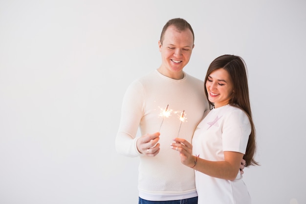 Valentines day concept young happy smiling cheerful attractive couple celebrating with sparklers on