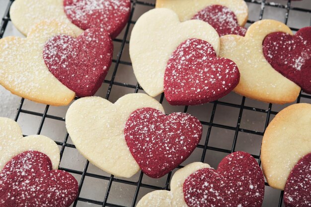 Valentines day cookies Shortbread cookies inside sweet red heart with chocolate glaze on pink plate on grey background Mothers day Womans day Sweet holidays baking Valentines day card Top view