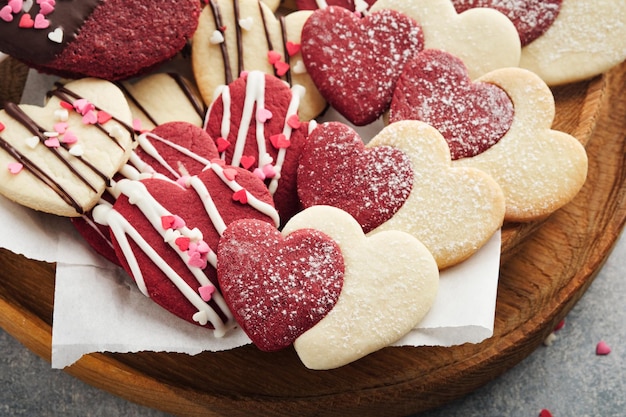 バレンタインデーのクッキー 灰色の背景にピンクのプレートにチョコレート釉で甘い赤いハートの中のショートブレッド クッキー母の日女性の日甘い休日ベーキング バレンタイン カード トップ ビュー