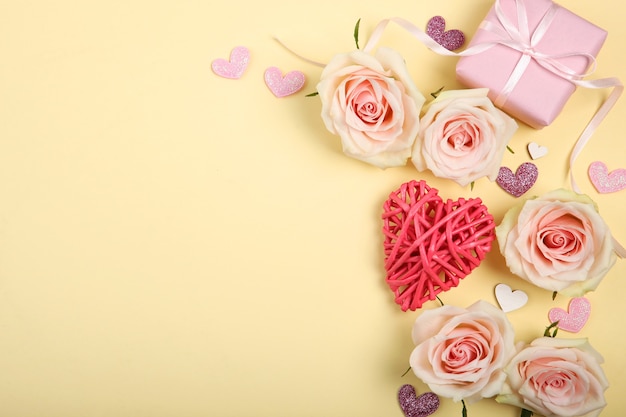 Valentines day decorations, bouquet and gift on yellow background