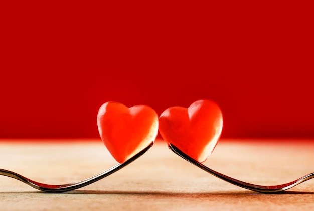 Valentines Day dinner background two forks holding red heart