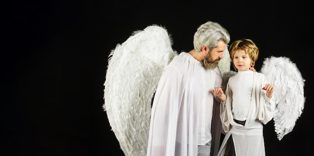 Valentines day father and son in angel wings little cupid boy and bearded man in white clothes