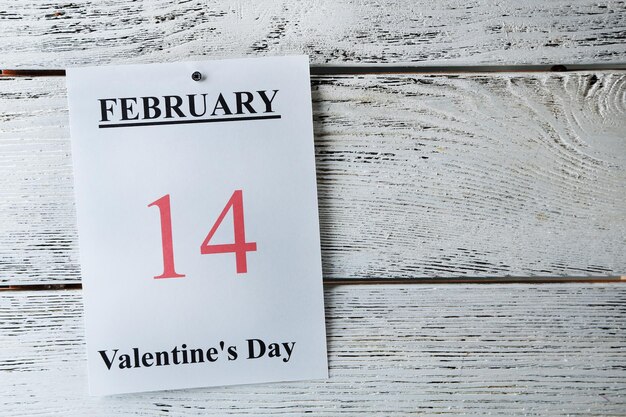 バレンタインデー、木製の背景のカレンダーの2月14日
