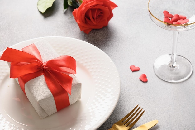 Cena festiva di san valentino con rosa rossa e regalo romantico