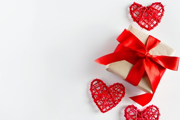 Photo valentines day gift and red hearts on a white background