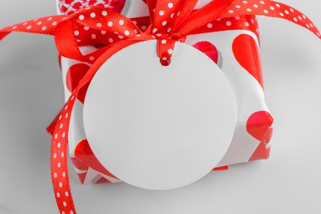 Photo valentines day gift with round white gift tag mockup on marble background with red heart sale and