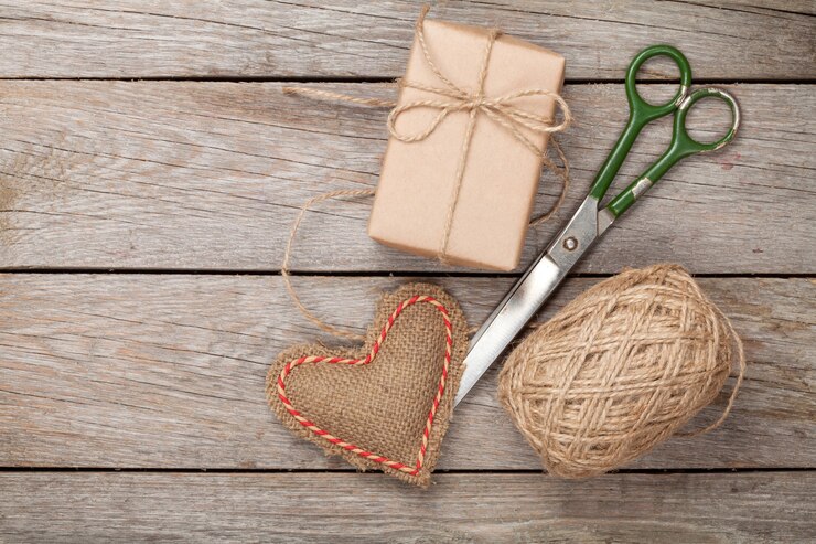 Photo valentines day gift wrapping with boxes and scissors over white wooden table
