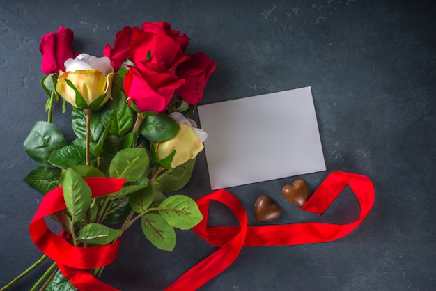 Valentines day greeting card concept with red rose flowers, champagne, chocolates and gift box