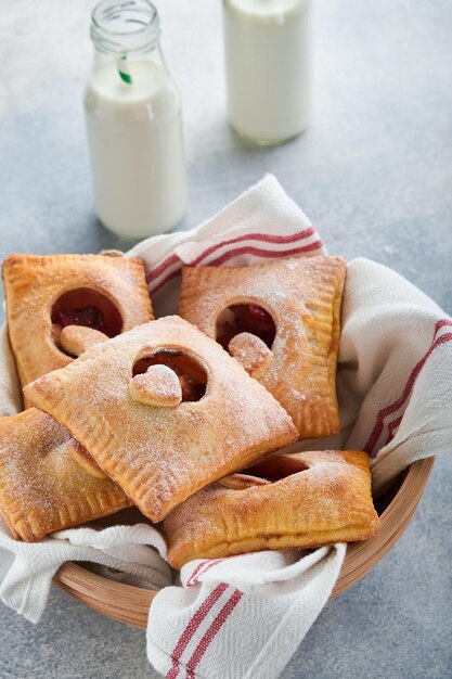 Valentines day heart shaped Hand pies Mini puff pastry or hand pies stuffed with apple and sprinkle sugar powder in plate Idea for homemade romantic snack Valentines day Top view Copy space