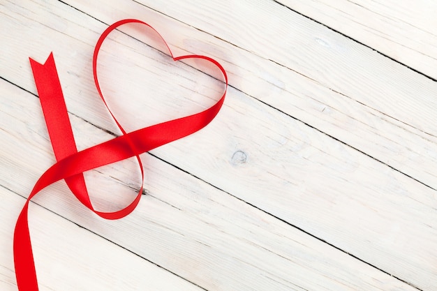 Valentines day heart shaped ribbon over white wooden table background with copy space