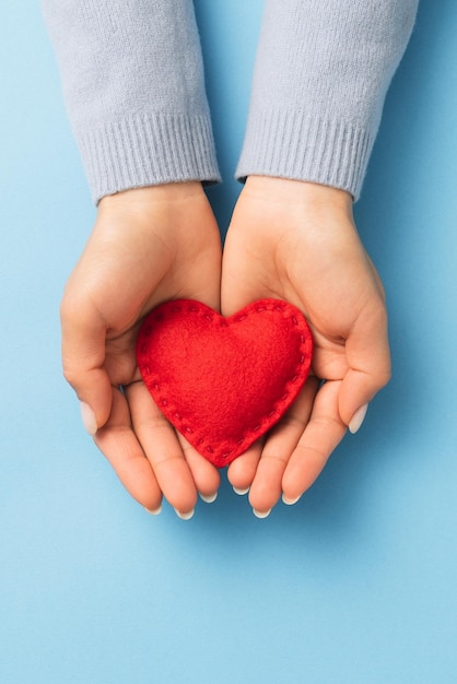 Concetto di espressione di amore di san valentino con cuore rosso sui palmi della donna