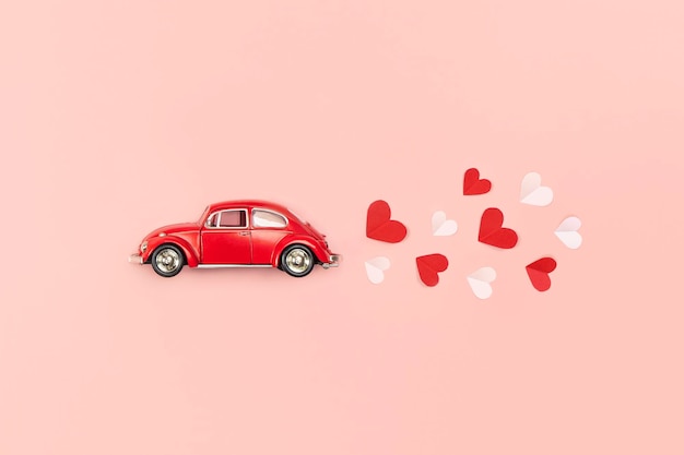 Valentines Day and Mother Day background Red hearts and retro car on pink background