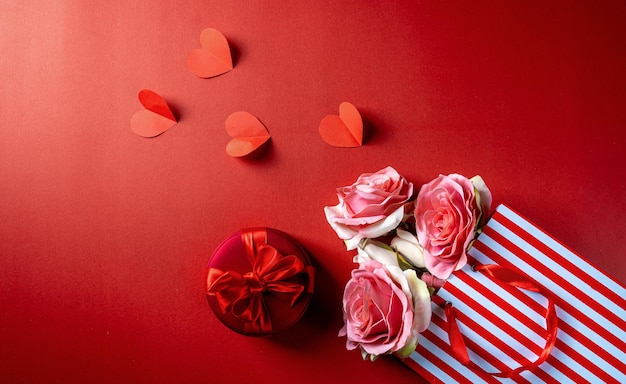 Valentines day red theme with flower, flower gift packet, gift
box and paper heart on the top.