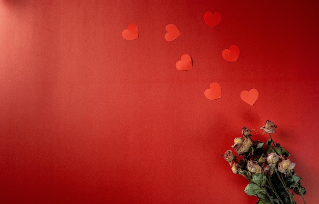 Красная тема дня святого валентина с бумажным сердцем и цветочными бутонами.