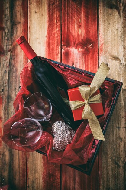バレンタインデーの赤ワインのボトルと箱の中のグラス