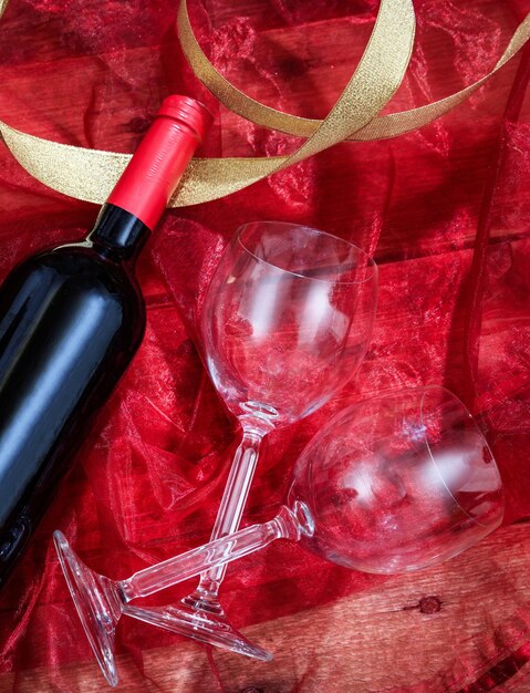 Valentines day Red wine bottle and glasses on red textile