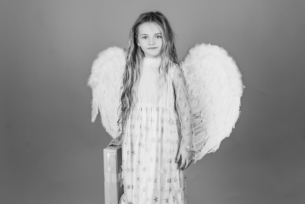 Valentines day Saint Valentines Day card Child wearing long white dress and angel wings Pretty little angel girl Angel child from heaven gives you gift