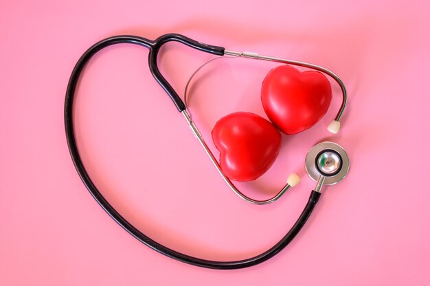 Valentines day and Sweetest day concept. Stethoscope with red heart on pink background. Love symbol for healthy and wellness