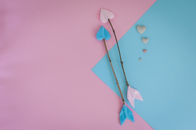 Valentines day twig arrows on pink and blue background with heart