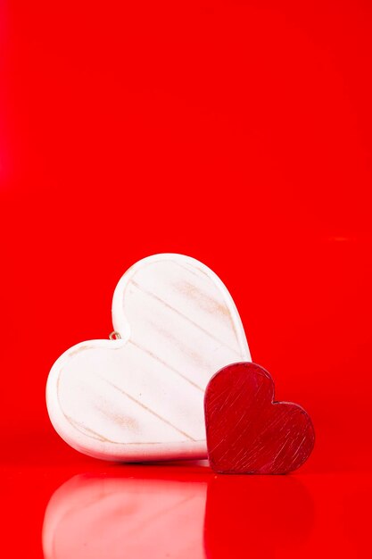 Valentines day two wooden hearts painted on red background portrait