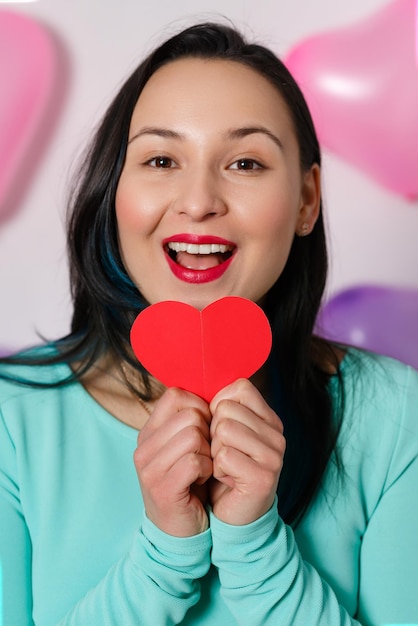 San valentino donna con il cuore nelle sue mani su sfondo bianco con le palle