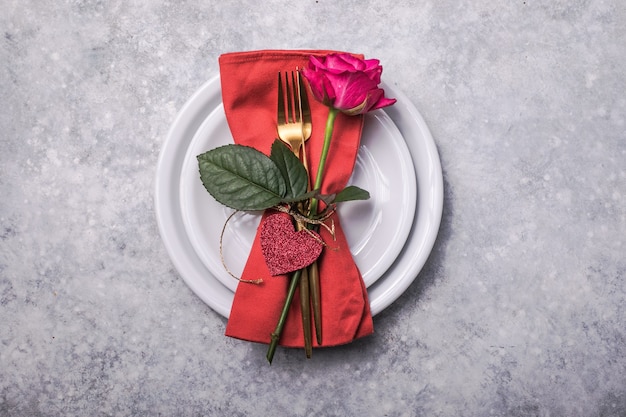 ハートの装飾を設定するテーブルの場所でのバレンタインディナー、バレンタインデーのディナーのためのバラ。上からの眺め。