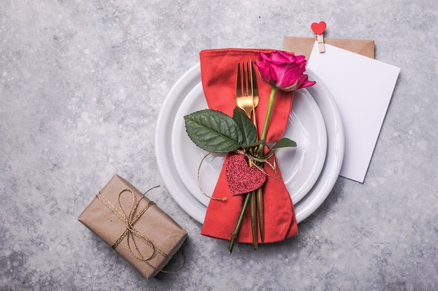 Valentines dinner with table place setting  hearts decoration, rose for valentines days dinner. View from above.