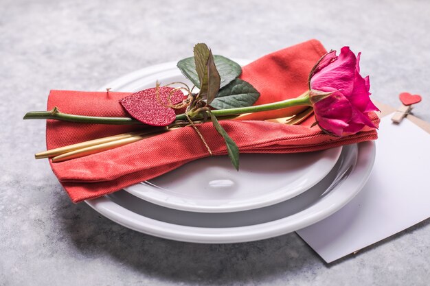 Valentines dinner with table place setting  hearts decoration, rose for valentines days dinner. View from above.