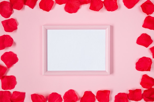 Valentines frame with rose petals, pink flat lay.