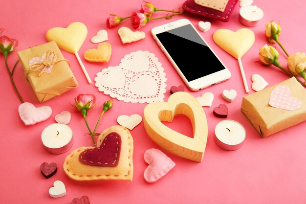 Valentines gift with sweets and decor on pink background top view