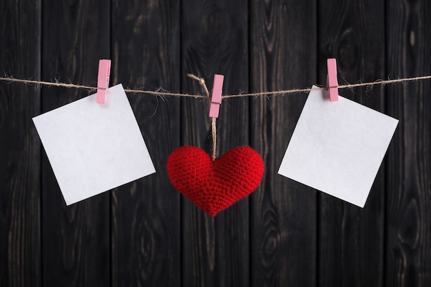 Valentines kaart met rood hart en papier stickers op touw.