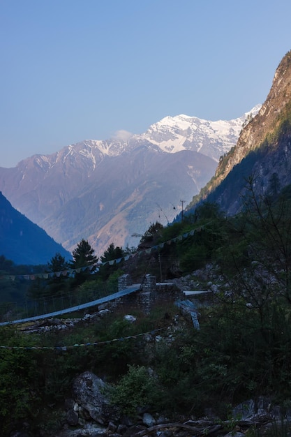 Vallei in de Himalaya een brug en besneeuwde bergtoppen op de achtergrond