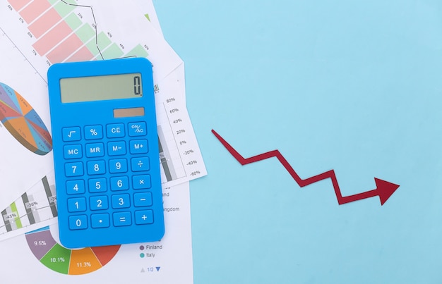 Vallende pijl die naar beneden neigt, grafieken en diagrammen, rekenmachine op een blauw. Symbool van de wereldwijde crisis