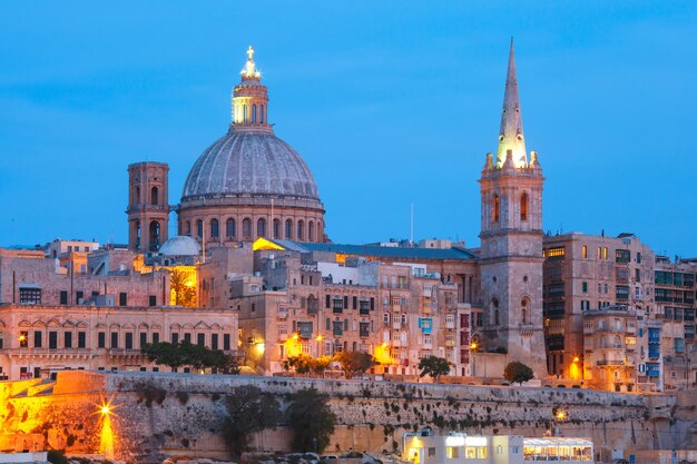 Valletta skyline from sliema with church of our lady of mount carmel and st. paul's anglican pro-cathedral during evening blue hour, valletta, capital city of malta