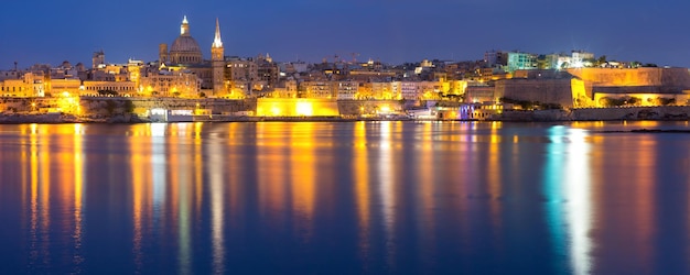 Valletta Skyline at night with church of Our Lady of Mount Carmel and St. Paul's Anglican Pro-Cathedral, Valletta, Capital city of Malta. Panoramic view from Sliema.