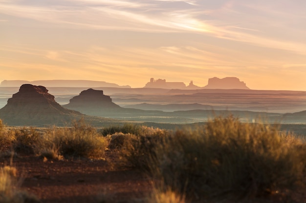 Valley of the Gods rock formation with Monument Valley at sunrise