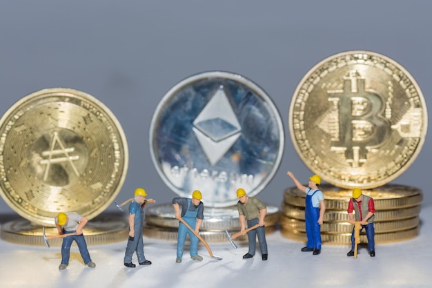 Valueable crypto coins bitcoin ether and ad with many worker in a row on gray background close up view