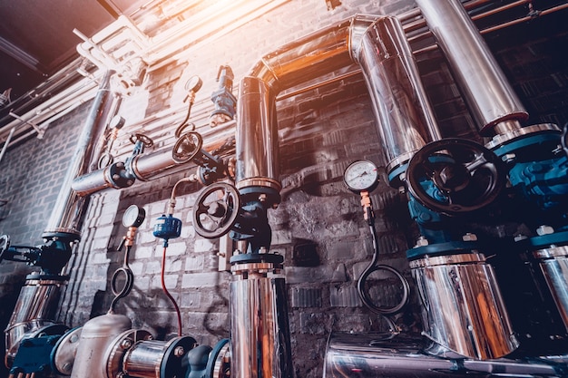 The valves and pipes at a craft modern brewery wall