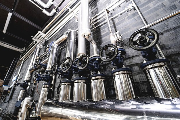 Клапаны и трубы на стене современного крафтового пивоваренного завода