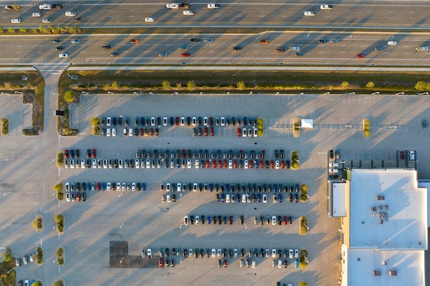 Van bovenaf bekijken van het parkeerterrein van dealers met veel gloednieuwe auto's op voorraad te koop aan de kant van de snelweg Concept van de ontwikkeling van de Amerikaanse auto-industrie
