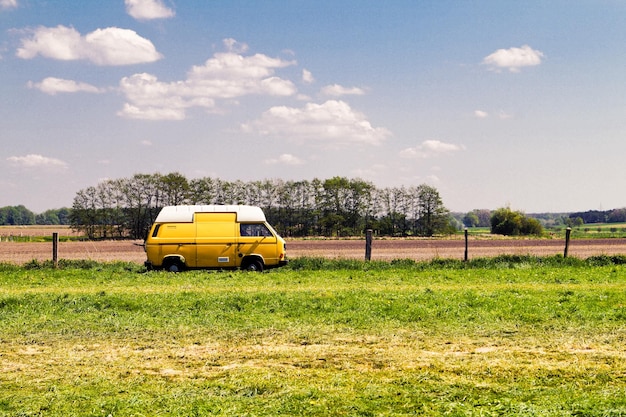 Van geparkeerd door het veld tegen de lucht