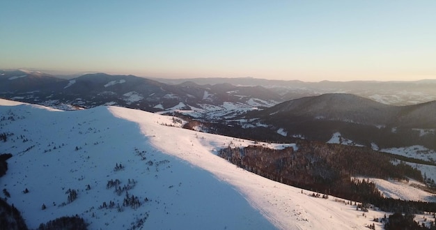 Van grote hoogte sprookjesachtig berglandschap besneeuwde alpine scherpe toppen Wilde winter in de Karpaten Oekraïne Dikke witte wolken Open ruimte luchtfoto 4K