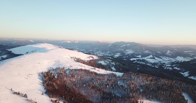 Van grote hoogte sprookjesachtig berglandschap besneeuwde alpine scherpe toppen wilde winter in de karpaten oekraïne dikke witte wolken open ruimte luchtfoto 4k