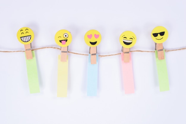 van vijf vrolijke smileygezichten met verschillende reactie opknoping op touw met papieren stickers geïsoleerde witte muur