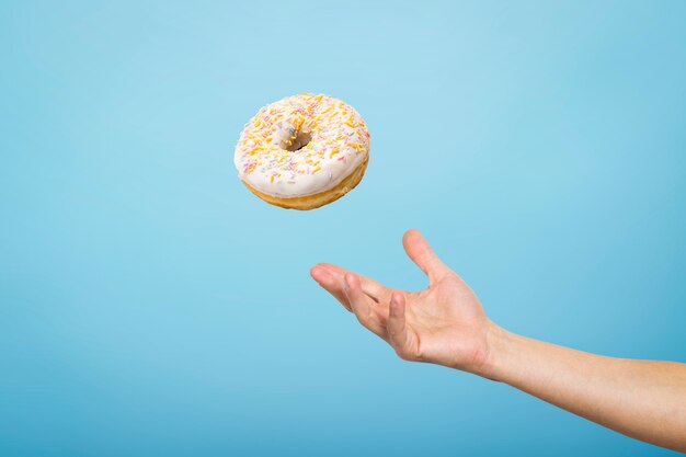 Vang een donut met de hand. Concept van het bakken, handgemaakt. Plat lag, bovenaanzicht