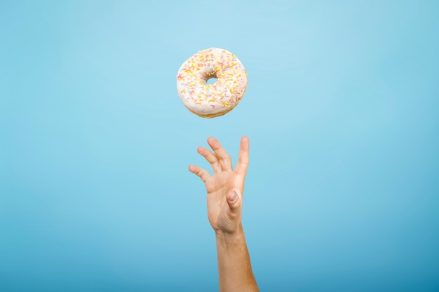 Vang een donut met de hand. Concept van het bakken, handgemaakt. Plat lag, bovenaanzicht