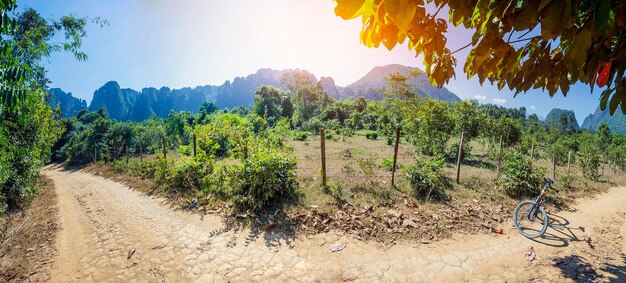 Vang Vieng, Laos. Bicycle parks on a country road, in the background of fields and beautiful mountains