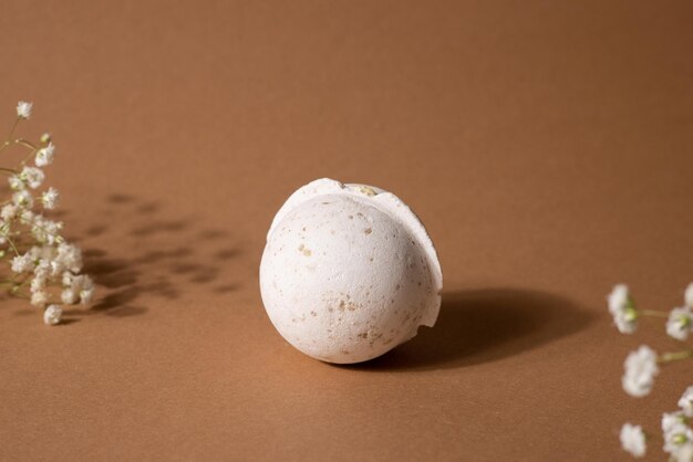 Vanilla aroma bath bomb in spa composition with dry flowers on brown background