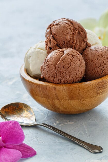 Vanilla and chocolate ice cream balls in a wooden bowl
